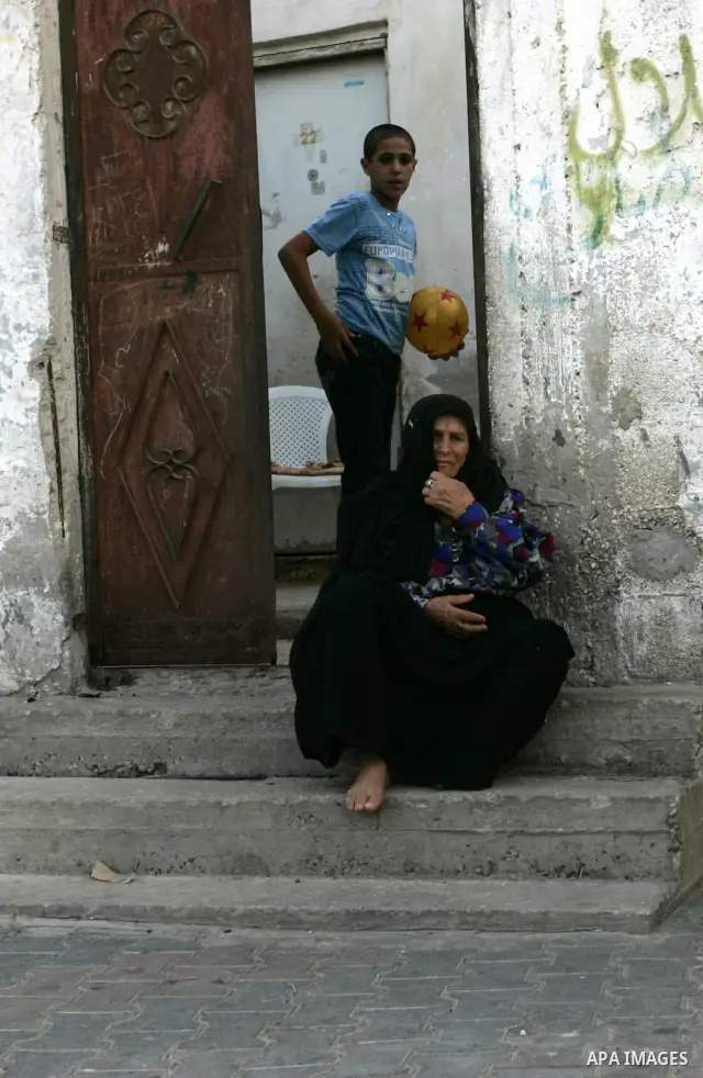 A Palestinian woman sits outside her house with her son in Rafah refugee camp, southern Gaza Strip on Sep. 24, 2011. Palestinian Authority President Mahmoud Abbas, hands over a formal letter to be admitted as a state to...