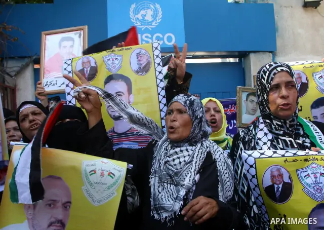 Palestinian women hold pictures of their prisoned relatives in Israeli jails infront of the UNSCO headquarters in Gaza City on Sep. 26, 2011. About 7000 prisoners are in Israeli jails according to the Palestinian prisone...