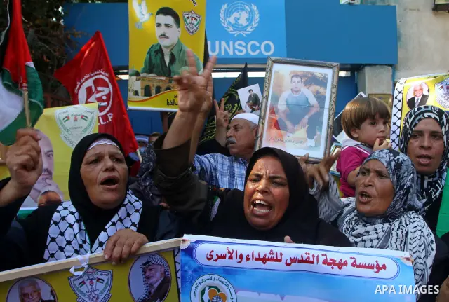 Palestinian women hold pictures of their prisoned relatives in Israeli jails infront of the UNSCO headquarters in Gaza City on Sep. 26, 2011. About 7000 prisoners are in Israeli jails according to the Palestinian prisone...