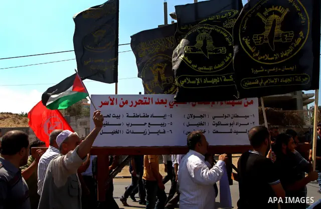 Palestinians hold flags and banners calling for the release of their prisoned relatives in Israeli jails, in Gaza City on Sep. 26, 2011. About 7000 prisoners are in Israeli jails according to the Palestinian prisoners mi...