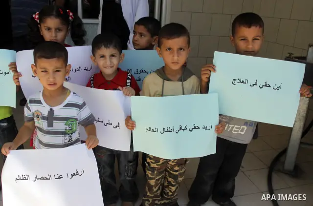 Palestinian doctors of Syndicate of Medical Professions and children hold posters during a protest at Abdel Aziz al-Rantisi hospital in Gaza city on Sep. 28, 2011. This protest organised against the lack of medicine.. Ph...
