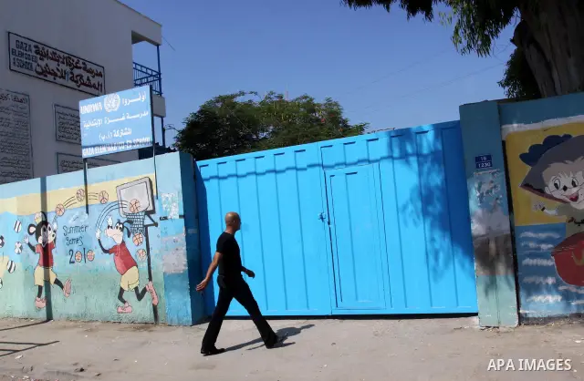 A Palestinian man walks in front of United Nations Relief and Works Agency (UNRWA) closed school, in Gaza City on Sept. 29, 2011, against the decision made to suspend Staff Union President, Suhail al-Hindi. Some 16 thous...