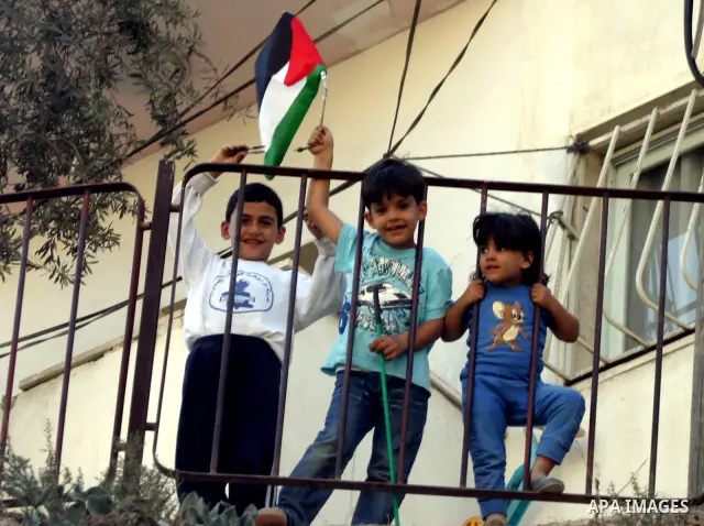 Palestinian children wave their national flag in the east Jerusalem neighborhood of Silwan, Thursday, Sept. 29, 2011. Israel on Tuesday approved construction of 1,100 homes for Jews on the annexed land in the West Bank,...