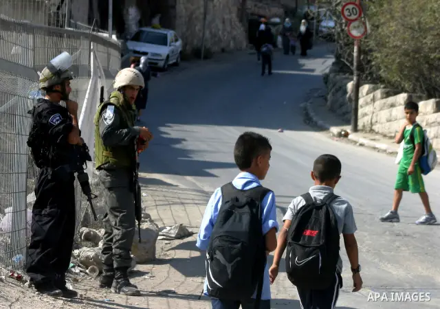 Palestinian schoolchildren walk past Israeli soldiers standing guard in the east Jerusalem neighborhood of Silwan, Thursday, Sept. 29, 2011. Israel on Tuesday approved construction of 1,100 homes for Jews on the annexed...