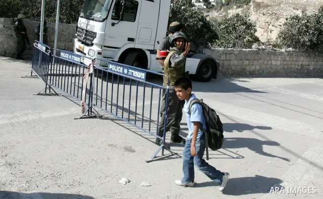 Palestinian schoolchildren walk past Israeli soldiers standing guard in the east Jerusalem neighborhood of Silwan, Thursday, Sept. 29, 2011. Israel on Tuesday approved construction of 1,100 homes for Jews on the annexed...