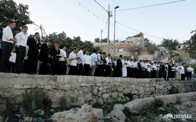 Jews gather to read prayers and perform 'Tashlich,' meaning to 'cast off,' near a small stream of water overlooking the arab East Jerusalem village of Silwan, at sun down on the first day of Jewish New Year, or Rosh Hash...