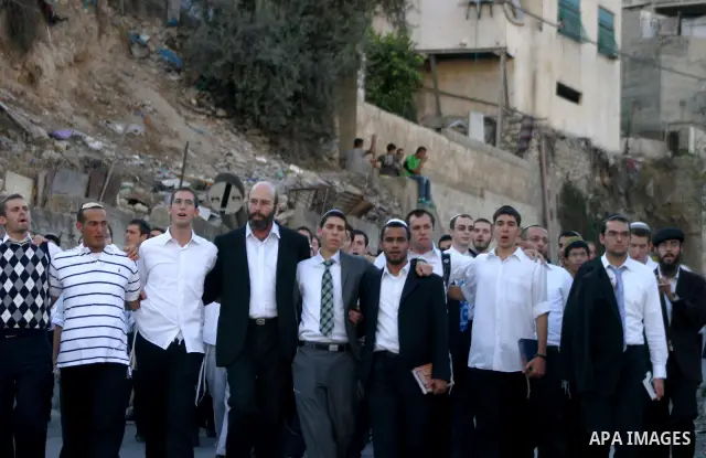 Jews gather to read prayers and perform 'Tashlich,' meaning to 'cast off,' near a small stream of water overlooking the arab East Jerusalem village of Silwan, at sun down on the first day of Jewish New Year, or Rosh Hash...