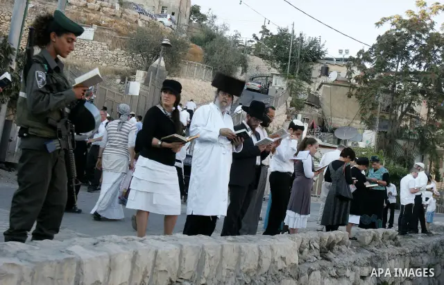 Jews gather to read prayers and perform 'Tashlich,' meaning to 'cast off,' near a small stream of water overlooking the arab East Jerusalem village of Silwan, at sun down on the first day of Jewish New Year, or Rosh Hash...