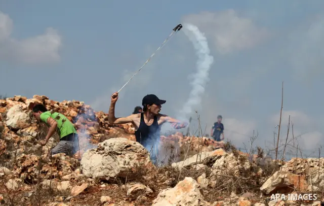 Palestinian youths clash with Israeli forces following a weekly demonstration against Israeli settlement expansion, in the West Bank village of Nabi Saleh, near the Jewish settlement of Halamish on September 30, 2011. Ph...