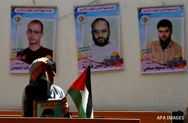 A Palestinian woman holds a picture of her relative during in a protest demanding for release of Palestinian prisoners in Israeli jails, at the Red Cross head headquarters in Gaza City on Oct. 4, 2011. Palestinians conti...