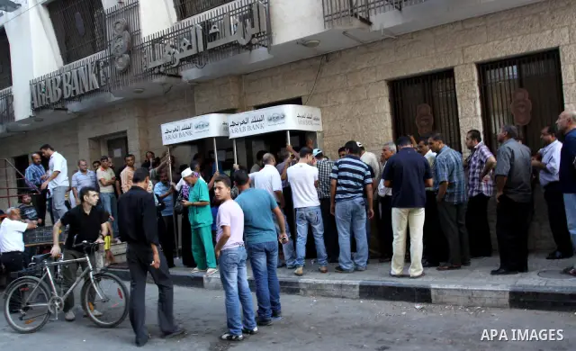 Palestinian Authority civil servants gather outside the Arab Bank in Gaza city on Oct. 04,2011, to withdraw their monthly salaries. Photo by Mohammed Asad