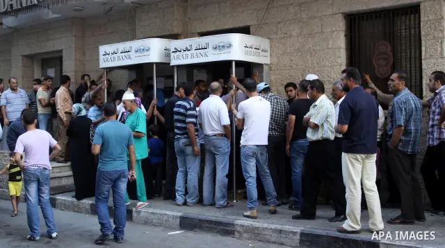 Palestinian Authority civil servants gather outside the Arab Bank in Gaza city on Oct. 04,2011, to withdraw their monthly salaries. Photo by Mohammed Asad