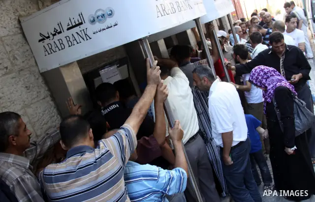 Palestinian Authority civil servants gather outside the Arab Bank in Gaza city on Oct. 04,2011, to withdraw their monthly salaries. Photo by Mohammed Asad