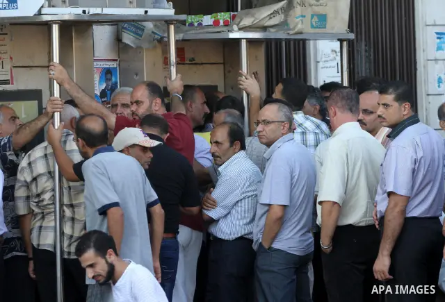 Palestinian Authority civil servants gather outside the Arab Bank in Gaza city on Oct. 04,2011, to withdraw their monthly salaries. Photo by Mohammed Asad