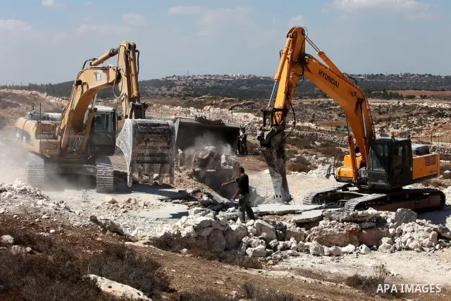 Israeli border police officers stand guard as demolition vehicles destroy a man-made reservoir on a Palestinian farm near the West Bank city of Hebron, on 04 October 2011. Reports state that tensions rose as Palestinian...