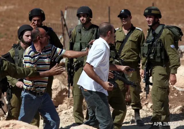 Israeli border police officers stand guard as demolition vehicles destroy a man-made reservoir on a Palestinian farm near the West Bank city of Hebron, on 04 October 2011. Reports state that tensions rose as Palestinian...