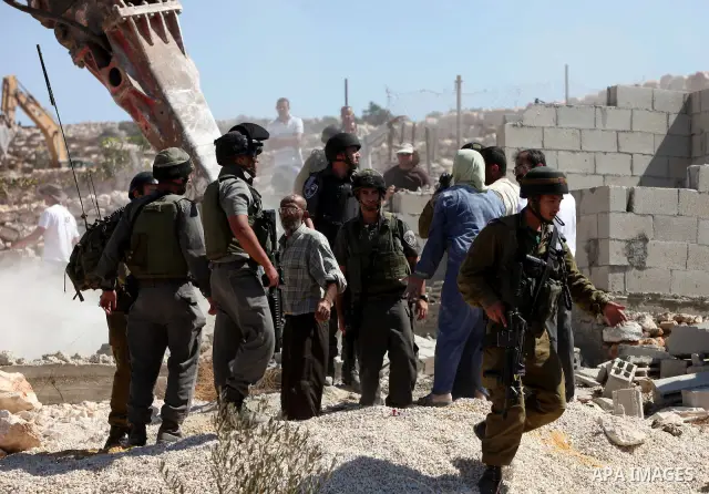 Israeli border police officers stand guard as demolition vehicles destroy a man-made reservoir on a Palestinian farm near the West Bank city of Hebron, on 04 October 2011. Reports state that tensions rose as Palestinian...