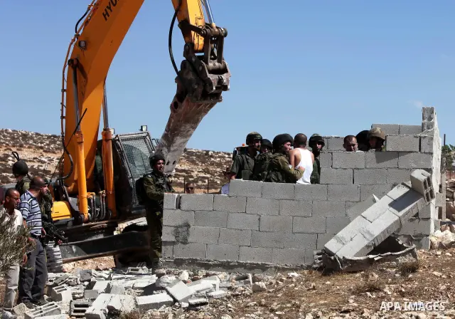 Israeli border police officers stand guard as demolition vehicles destroy a man-made reservoir on a Palestinian farm near the West Bank city of Hebron, on 04 October 2011. Reports state that tensions rose as Palestinian...