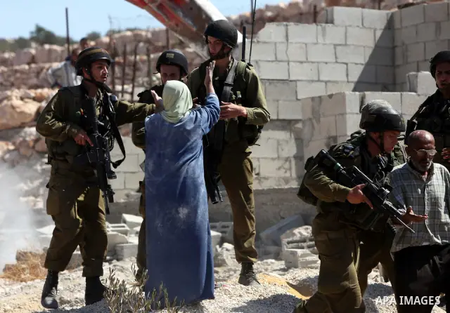 Israeli border police officers stand guard as demolition vehicles destroy a man-made reservoir on a Palestinian farm near the West Bank city of Hebron, on 04 October 2011. Reports state that tensions rose as Palestinian...