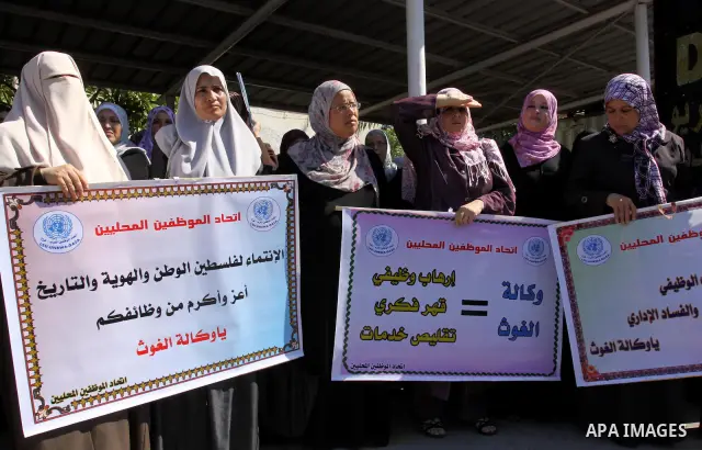 Palestinians take part in a protest against the decision to stop the head of the Federation of staff, Suhail al-Hindi to work temporarily, in front of the UNRWA headquarters in Gaza City on Oct. 5,2011. Union officials c...