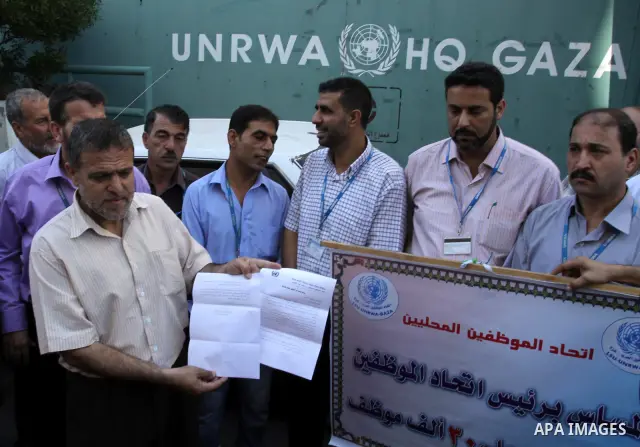 Palestinians take part in a protest against the decision to stop the head of the Federation of staff, Suhail al-Hindi to work temporarily, in front of the UNRWA headquarters in Gaza City on Oct. 5,2011. Union officials c...