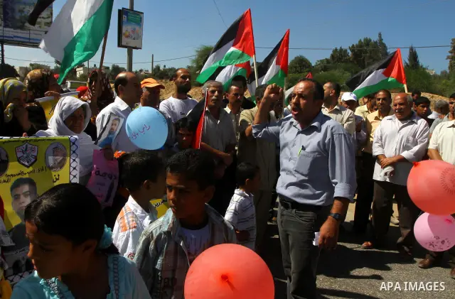 Palestinians take part in a protest near the Erez border crossing between Israel and northern Gaza Strip October 5, 2011, to show their solidarity with Palestinian prisoners held in Israeli jails. Hundreds of Palestinian...