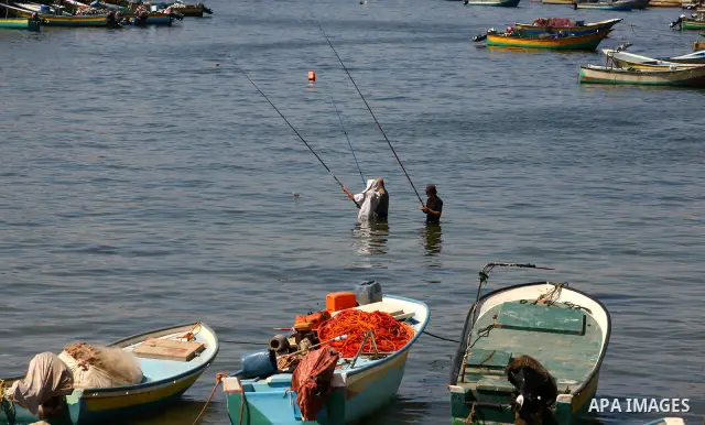 Palestinian men fish as others participate in a press conference at the Gaza Seaport on Oct. 5, 2011 against the violations of Israeli forces against the Palestinian fishermen in the Mediterranean Sea.. Photo by Majdi Fa...