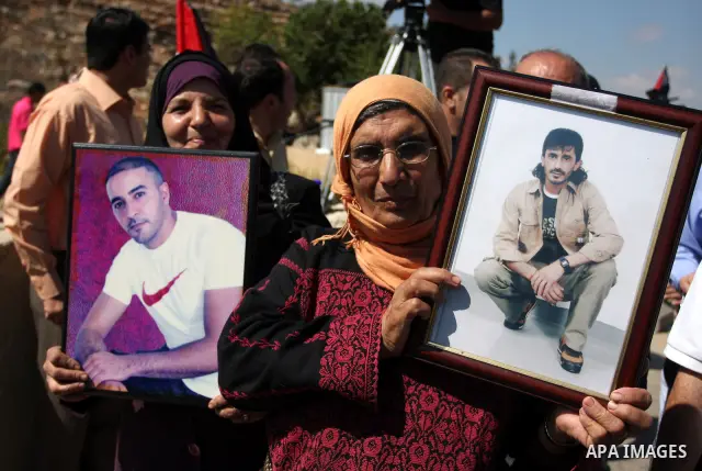 Palestinian protestors take part a demonstration calling for the release of prisoners held in Israeli jails and in support of inmates in hunger strike, on October 5, 2011 near Israel's Ofer prison, between Jerusalem and...