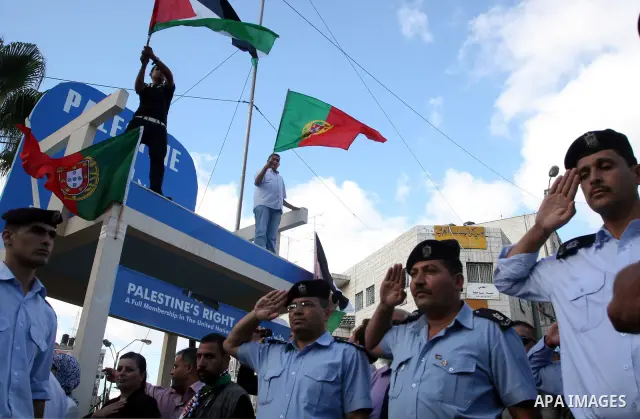 Palestinians wave their national flag and Portugal flag as they celebrate the National Day of Portugal in the West Bank city of Ramallah October 6, 2011. Palestinians have demanded the State of Portugal to vote for the r...