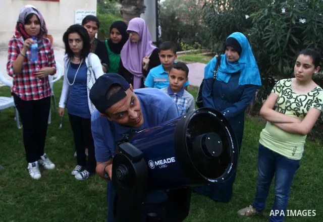 Palestinians look at the moon through a small telescope brought into Gaza City by the French Cultural Center (CCF) on Oct, 6, 2011. The CCF gave Gazan children and youths the opportunity to look at the stars and planets...