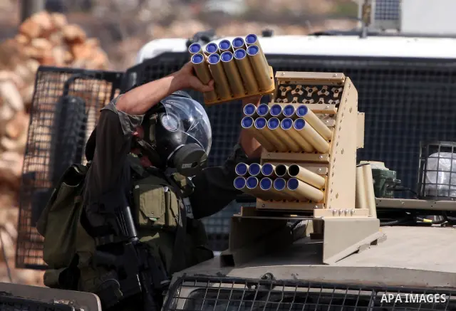 Israeli forces use a tear gas canister launcher to disperse Palestinian stone throwers during clashes following a weekly demonstration against Israeli settlement expansion, in the West Bank village of Nabi Saleh, on Octo...
