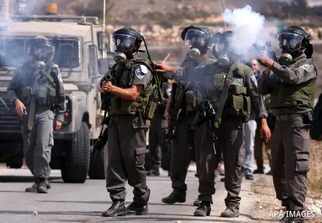 Israeli soldiers fire tear gas canister to disperse Palestinian stone throwers during clashes following a weekly demonstration against Israeli settlement expansion, in the West Bank village of Nabi Saleh, on October 7, 2...