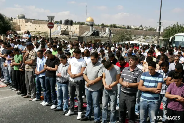 Palestinian Muslims attend Friday prayers at a street in the neighbourhood of Ras al-Amud, in East Jerusalem (Al-Aqsa Mosque compound in the background) on October 7,2011. Israel limited access to Jerusalem's Al-Aqsa mos...
