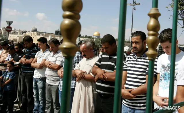 Palestinian Muslims attend Friday prayers at a street in the neighbourhood of Ras al-Amud, in East Jerusalem (Al-Aqsa Mosque compound in the background) on October 7,2011. Israel limited access to Jerusalem's Al-Aqsa mos...