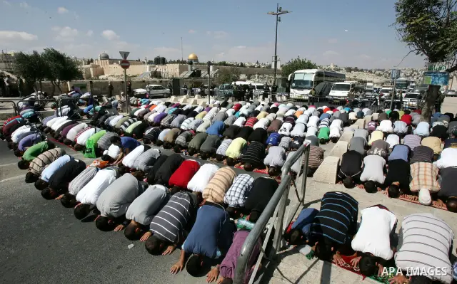Palestinian Muslims attend Friday prayers at a street in the neighbourhood of Ras al-Amud, in East Jerusalem (Al-Aqsa Mosque compound in the background) on October 7,2011. Israel limited access to Jerusalem's Al-Aqsa mos...
