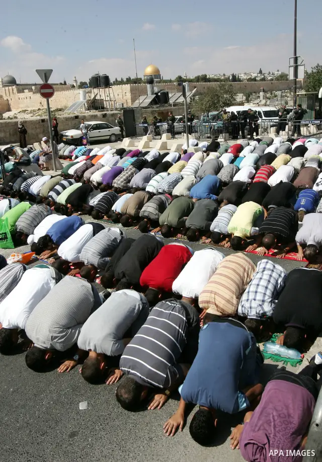 Palestinian Muslims attend Friday prayers at a street in the neighbourhood of Ras al-Amud, in East Jerusalem (Al-Aqsa Mosque compound in the background) on October 7,2011. Israel limited access to Jerusalem's Al-Aqsa mos...