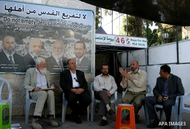 Palestinians and foreigners sit at the Red Cross compound in east Jerusalem on Oct. 9, 2011 in support with Hamas lawmaker Ahmad Atun. Atun is one of three senior Hamas MPs who took refugee inside the ICRC building in Ju...