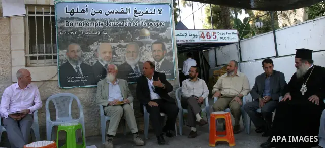 Palestinians and foreigners sit at the Red Cross compound in east Jerusalem on Oct. 9, 2011 in support with Hamas lawmaker Ahmad Atun. Atun is one of three senior Hamas MPs who took refugee inside the ICRC building in Ju...