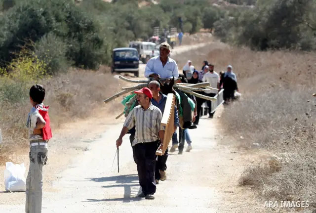 Palestinians leave their land after settlers clashed with Palestinian farmers from the village of Awarta in the Israeli occupied West Bank, on October 9, 2011, as they tried to pick olives from land owned by the family o...