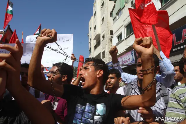 Palestinians take part in a protest in solidarity with Palestinian prisoners held in Israeli jails, in front of the International Red Cross building in Gaza City, Monday, Oct. 10, 2011. Gaza's Hamas rulers have imposed n...
