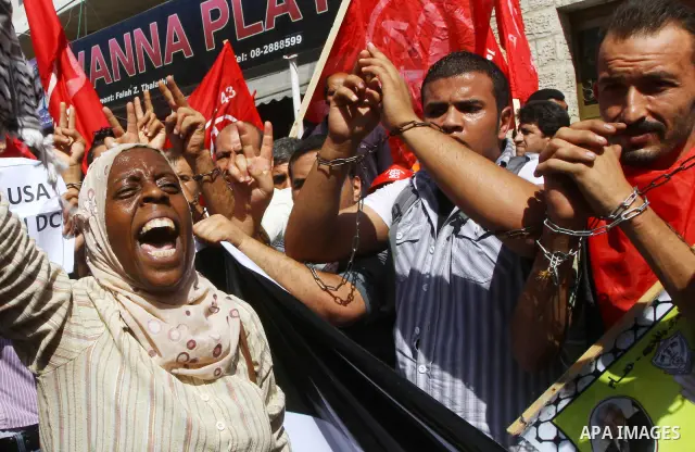 Palestinians take part in a protest in solidarity with Palestinian prisoners held in Israeli jails, in front of the International Red Cross building in Gaza City, Monday, Oct. 10, 2011. Gaza's Hamas rulers have imposed n...