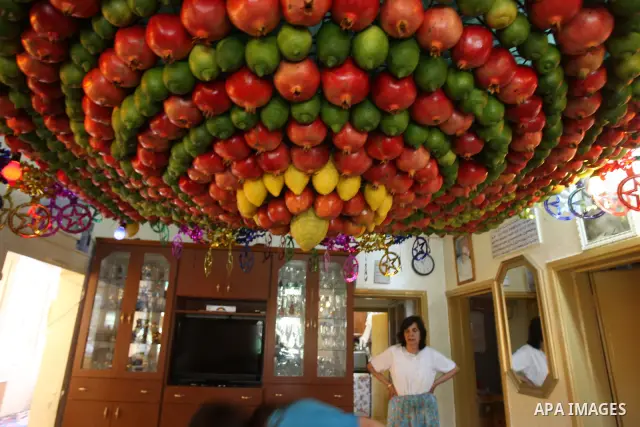 A woman from the ancient Samaritan community decorates a Sukkah made from fresh fruit for the holiday of the Tabernacles, or Sukkot, in Mount Gerizim near the West Bank town of Nablus, Monday, Oct. 10, 2011. The Sukkah i...