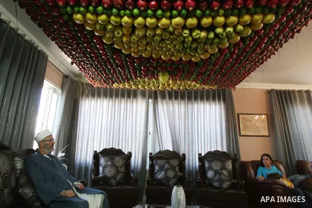 A man from the ancient Samaritan community decorates a Sukkah made from fresh fruit for the holiday of the Tabernacles, or Sukkot, in Mount Gerizim near the West Bank town of Nablus, Monday, Oct. 10, 2011. The Sukkah is...