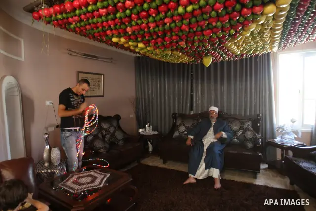 A man from the ancient Samaritan community decorates a Sukkah made from fresh fruit for the holiday of the Tabernacles, or Sukkot, in Mount Gerizim near the West Bank town of Nablus, Monday, Oct. 10, 2011. The Sukkah is...