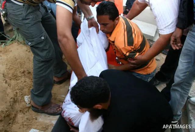 Palestinians gather around the body of Ahmed Azazmeh, killed in an explosion, during his funeral in Beit Hanoun, near the Erez Crossing between Gaza Strip and Israel, Monday, Oct. 10, 2011. Palestinian officials in the G...