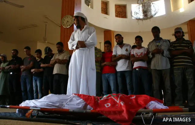 Palestinians pray as they gather around the body of Ahmed Azazmeh, killed in an explosion, during his funeral in a mosque in Beit Hanoun, near the Erez Crossing between Gaza Strip and Israel, Monday, Oct. 10, 2011. Pales...