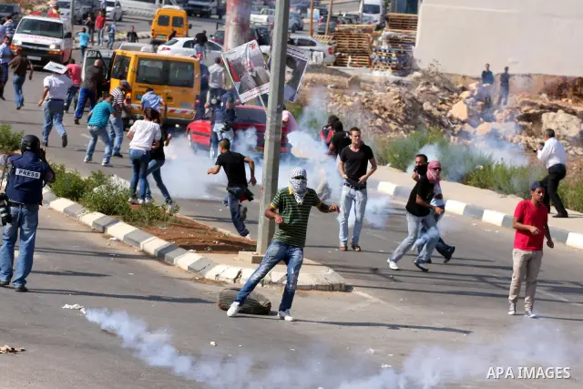 Palestinian protestors clash with Israeli forces following a demonstration calling for the release of prisoners held in Israeli jails and in support of inmates in hunger strike, on October 11, 2011 near Israel's Ofer pri...
