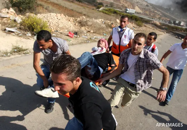 An injured Palestinian is helped by colleagues during clashes with Israeli forces following a demonstration calling for the release of prisoners held in Israeli jails and in support of inmates in hunger strike, on Octobe...