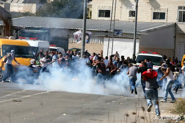 Palestinian protestors run for cover as Israeli forces fire tear gas canisters during clashes following a demonstration calling for the release of prisoners held in Israeli jails and in support of inmates in hunger strik...