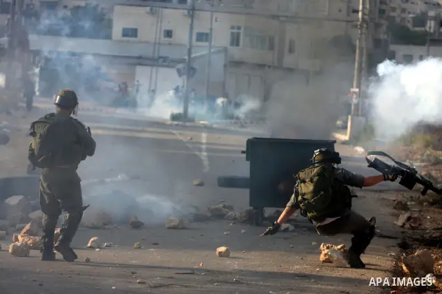 An Israeli soldier falls on the ground during clashes with Palestinians following a demonstration calling for the release of prisoners held in Israeli jails and in support of inmates in hunger strike, on October 11, 2011...